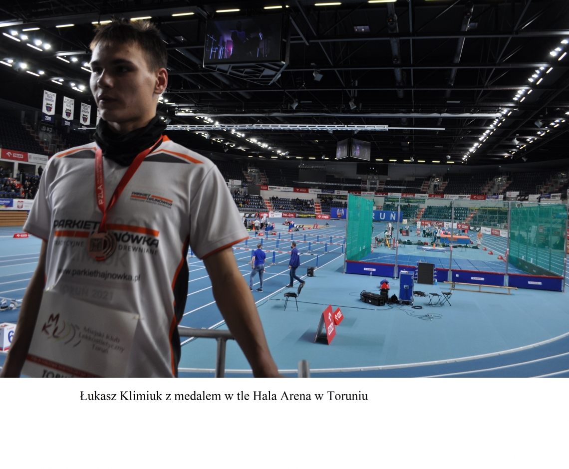Łukasz Klimiuk z medalem w tle Hala Arena w Toruniu