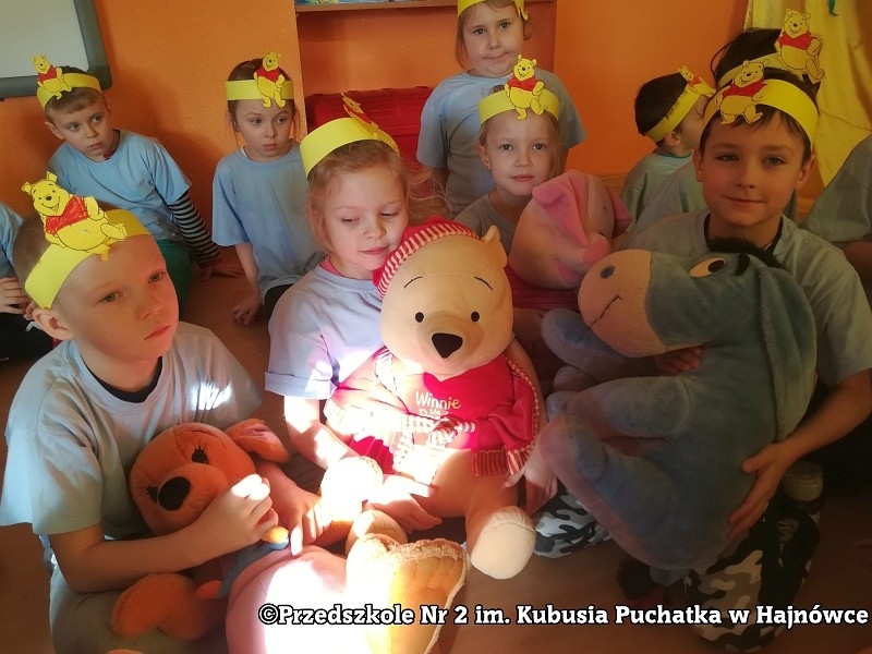Grupa dziec z maskotką Misia Puchatka.