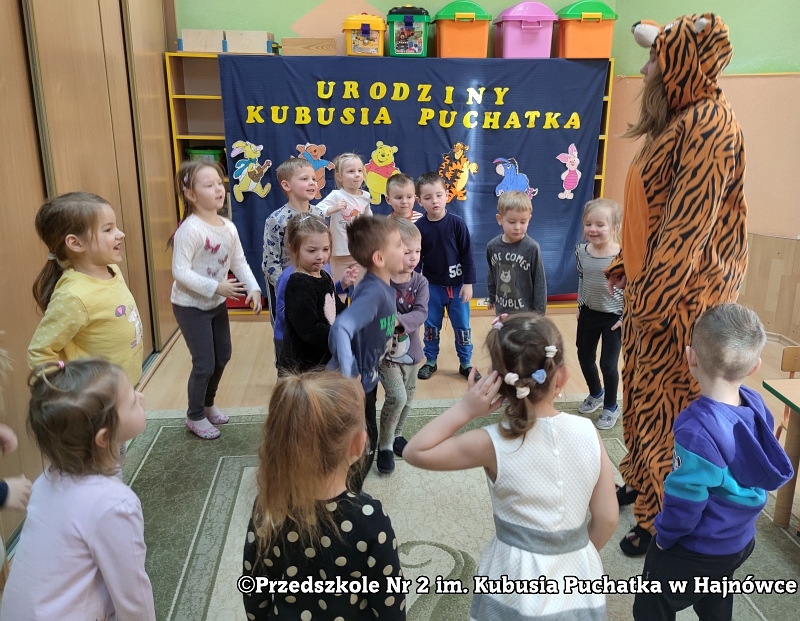 Zdjęcie ukazuje zabawy muzyczne z postaciami Prosiaczka, Kangurzycy i Kłapouchego, pokonywanie przeszkód (kamieni), slalom między pachołkami i przejście w tunelu.