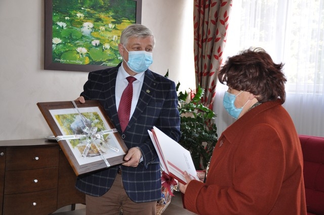 Burmistrz Miasta Hajnówka wręcza obraz córce jubilatki