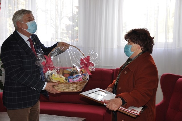 Burmistrz Miasta Hajnówka wręcza kosz ze słodyczami córce jubilatki