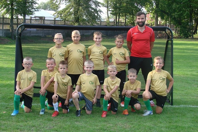 Grupa Trampkarzy Starszych stojąca na tle bramki