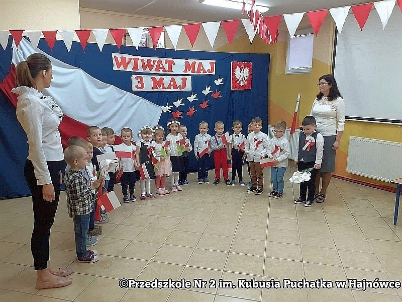 Dwóch chłopców z grupy IV Króliczki pokazują gazetę ścienną dotyczącą tematyki patriotycznej "Polskie symbole i barwy ojczyste".