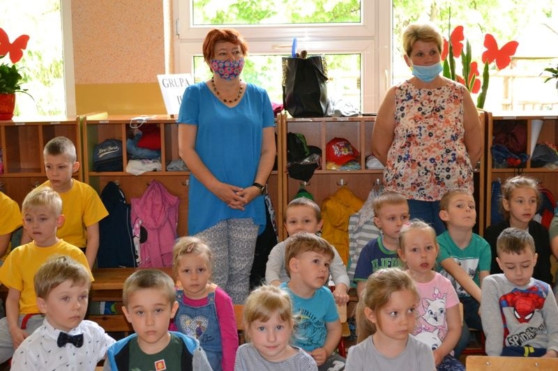 Uczestnicy konkursu siedzą na krzesłach w szatni.