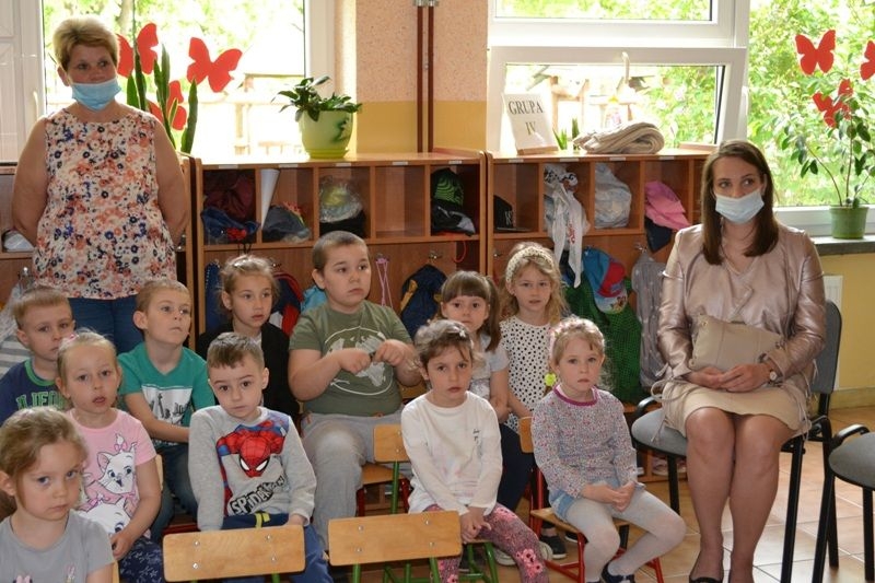 Uczestnicy konkursu siedzą na krzesłach w szatni.