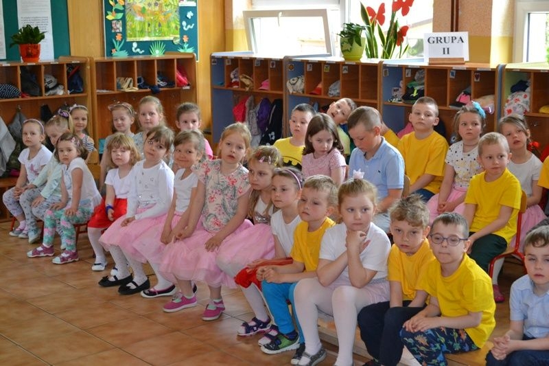 Uczestnicy konkursu siedzą na krzesłach w szatni.