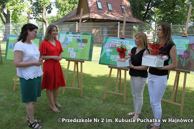 Uroczyste otwarcie wystawy. Cztery kobiety pozują do zdjecia. W tle widać wystawę.