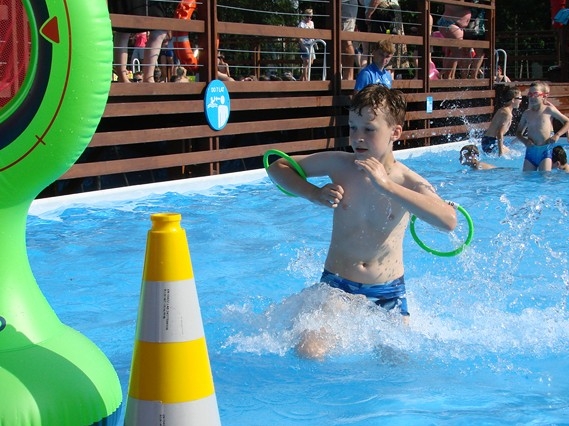 Chłopiec biegnie po wodzie w basenie.