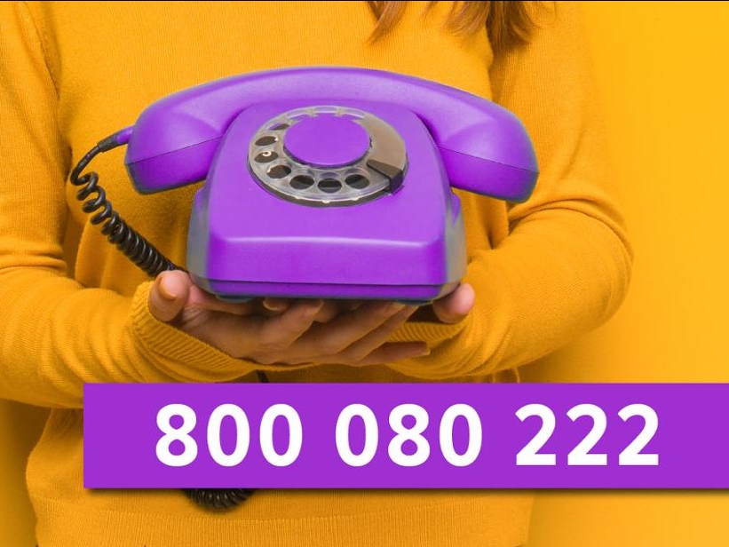 Na żółtym tle fioletowy telefon i numer telefonu.