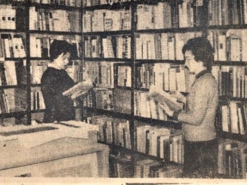skan czarno-białego zdjęcia prasowego, na którym widoczne są dwie kobiety, każda z nich trzyma książkę w ręku; za nimi stoją regały wypełnione książkami