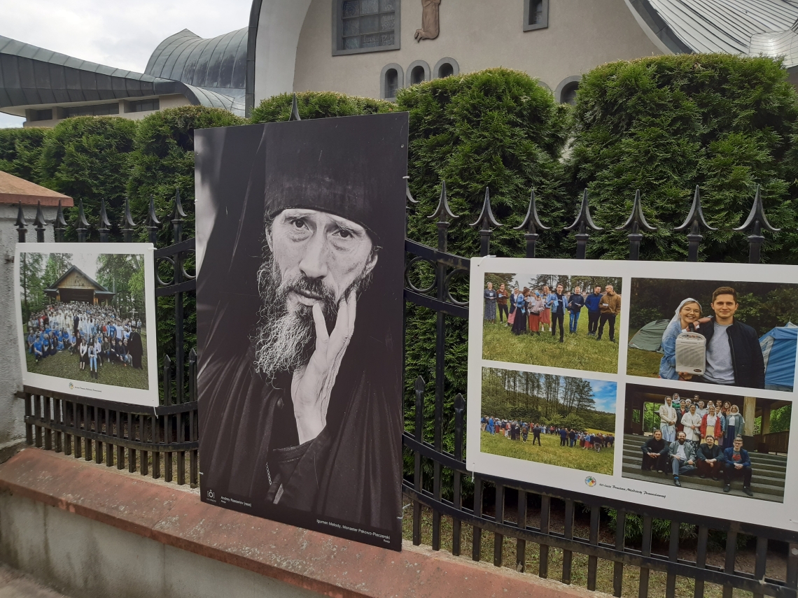 trzy wielkoformatowe zdjęcia zawieszone na ogrodzeniu