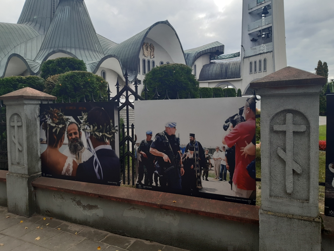 dwa wielkoformatowe zdjęcia zawieszone na ogrodzeniu