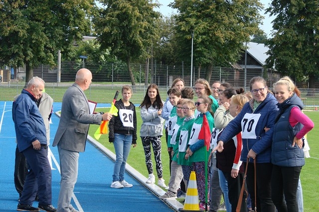 Uczestnicy spartakiady stoją z prowadzącym.