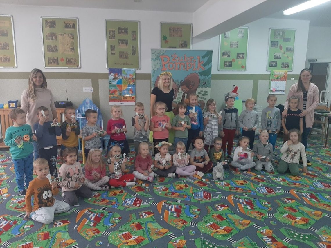 zdjęcie grupowe przedszkolaków na tle pompikowych banerów