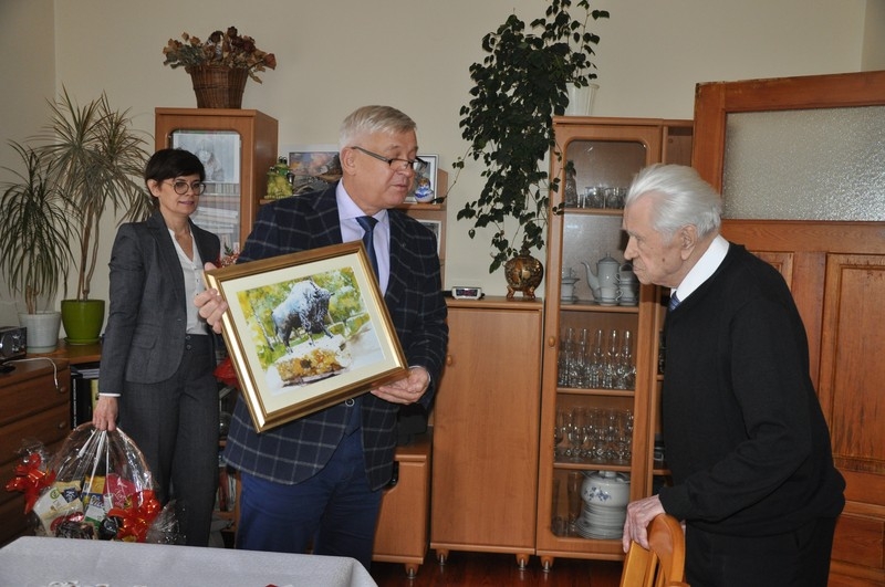burmistrz wręcza jubilatowi obraz Zbigniewa Budyńskiego
