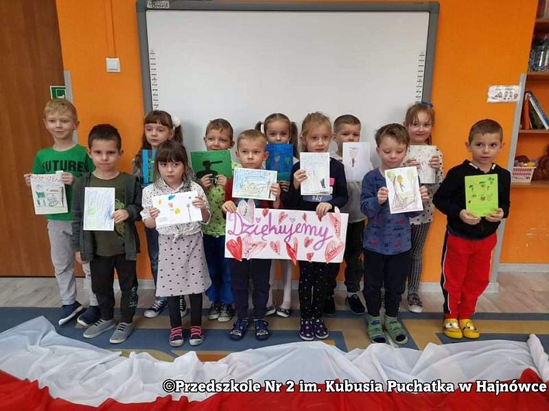 Zdjęcie grupowe dzieci prezentujących swoje prace plastyczne