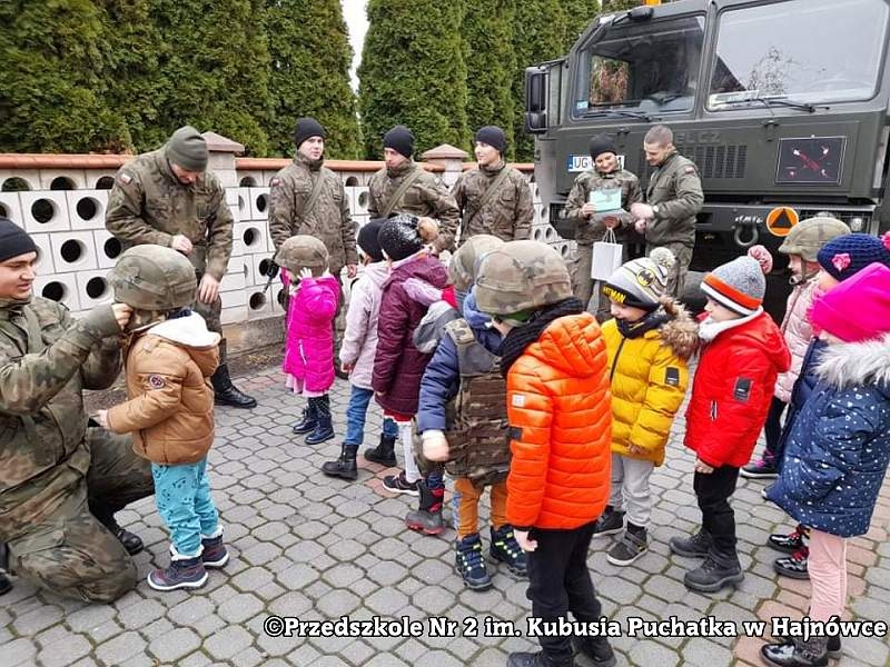 Zdjęcie dzieci i żołnieży, stoją na placu przed przedszkolem