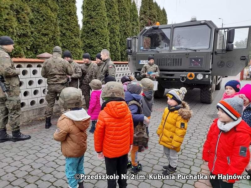 Zdjęcie dzieci i żołnieży, stoją na placu przed przedszkolem
