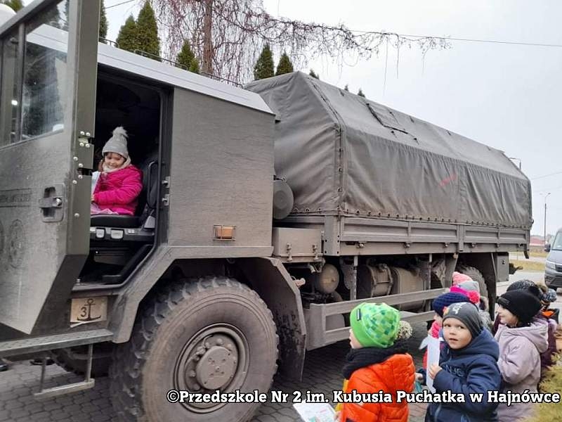 Zdjęcie dzieci i żołnieży, stoją na placu przed przedszkolem