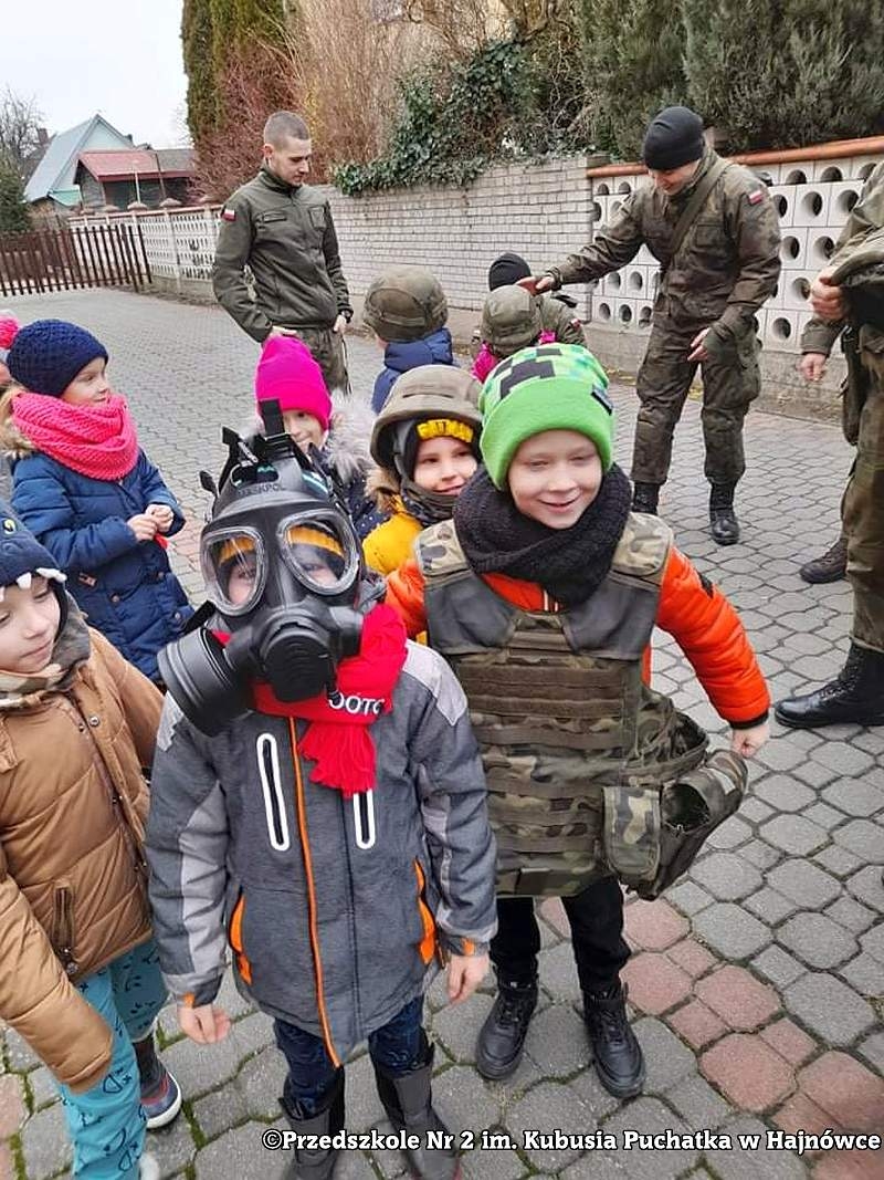 Zdjęcie dzieci i żołnieży, stoją na placu przed przedszkolem