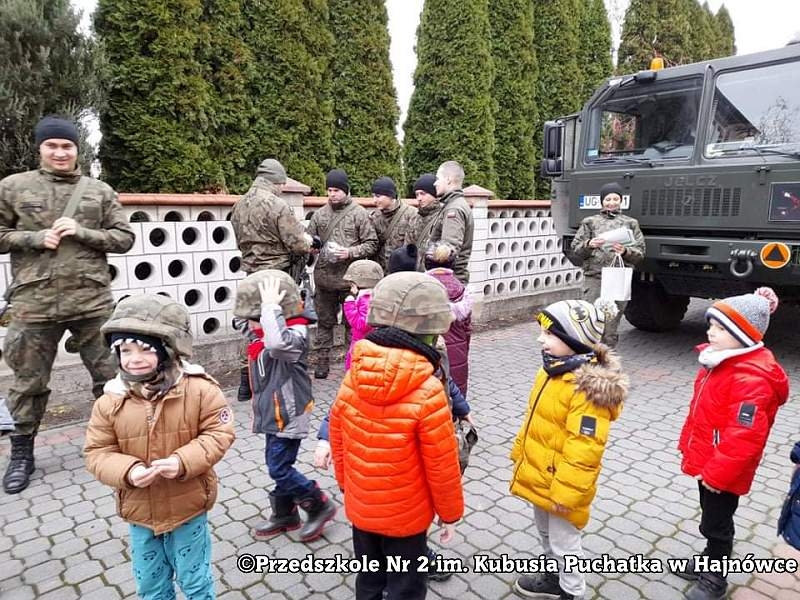 Zdjęcie dzieci i żołnieży, stoją na placu przed przedszkolem