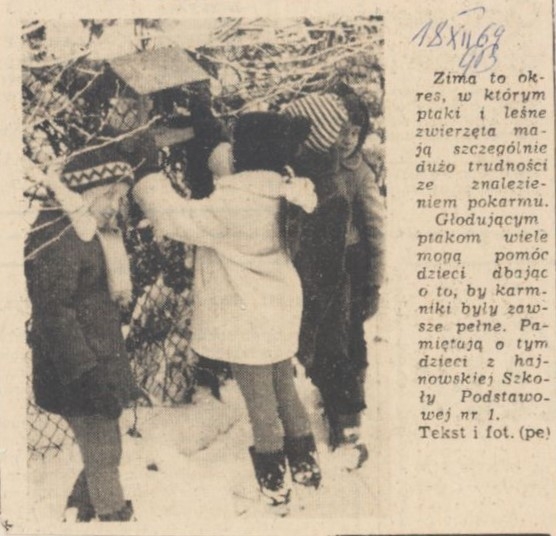 18.12.1969, Gazeta Białostocka; Podpis obok zdjęcia: Zima to okres, w którym ptaki i leśne zwierzęta mają szczególnie dużo trudności ze znalezieniem pokarmu. Głodującym ptakom wiele mogą pomóc dzieci dbając o to, by karmniki były zawsze pełne. Pamiętają o tum dzieci z hajnowskiej Szkoły Podstawowej nr 1. [skan czarno-białego zdjęcia prasowego; czworo dzieci stoi przy karmniku dla ptaków i dosypuje ziarno]