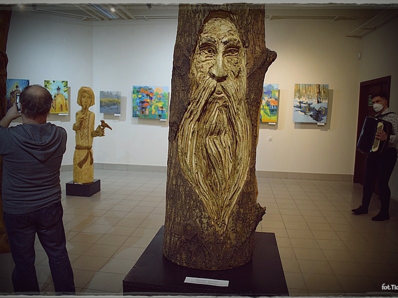 W centrum stri duża rzeźba przedstawqiająca mężczyznę z długa brodą, w tle widać wystawę