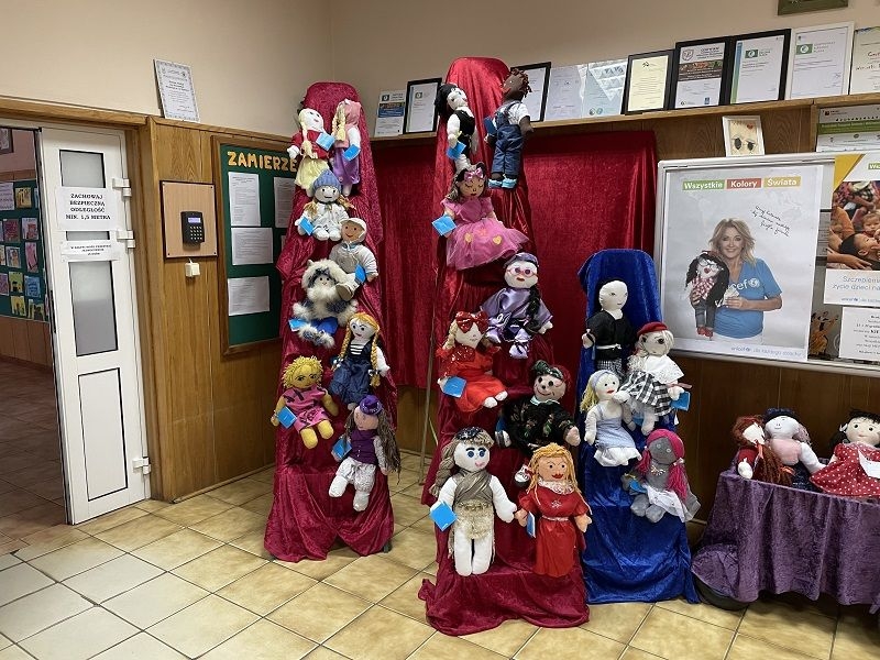Ekspozycja lalek w holu przedszkola. Lalki zostały przygotowane przez rodziców i dzieci na kiermasz w związku z akcją UNICEF „Wszystkie kolory świata”.