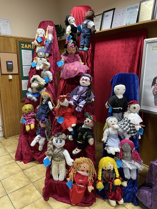 Ekspozycja lalek w holu przedszkola. Lalki zostały przygotowane przez rodziców i dzieci na kiermasz w związku z akcją UNICEF „Wszystkie kolory świata”.