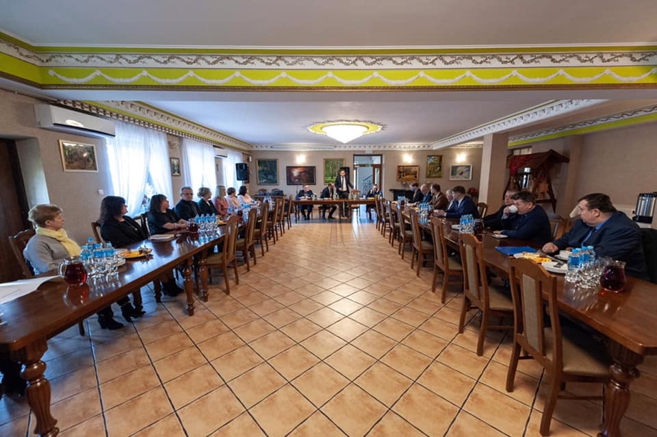 w sali konferencyjnej przy stołach ustawionych w literę U siedzą goście przybyli na spotkanie