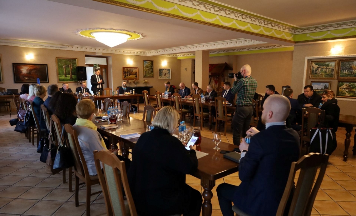 w sali konferencyjnej przy stołach ustawionych w literę U siedzą goście przybyli na spotkanie