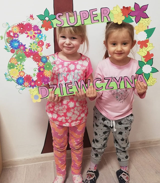 Dwie dziewczynki trzymają  ramkę z napisem Super dziewczyna.