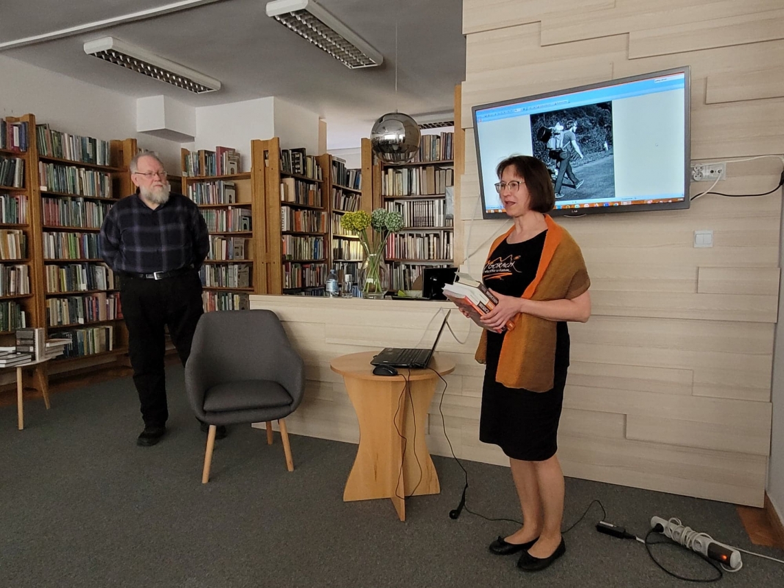 mężczyzna a za nim regały z książkami i kobieta przedstawiająca autora