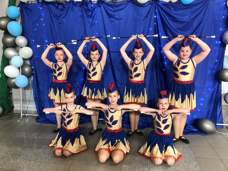 Marżoretki pozują do zdjęcia grupowego na biebieskim tle.