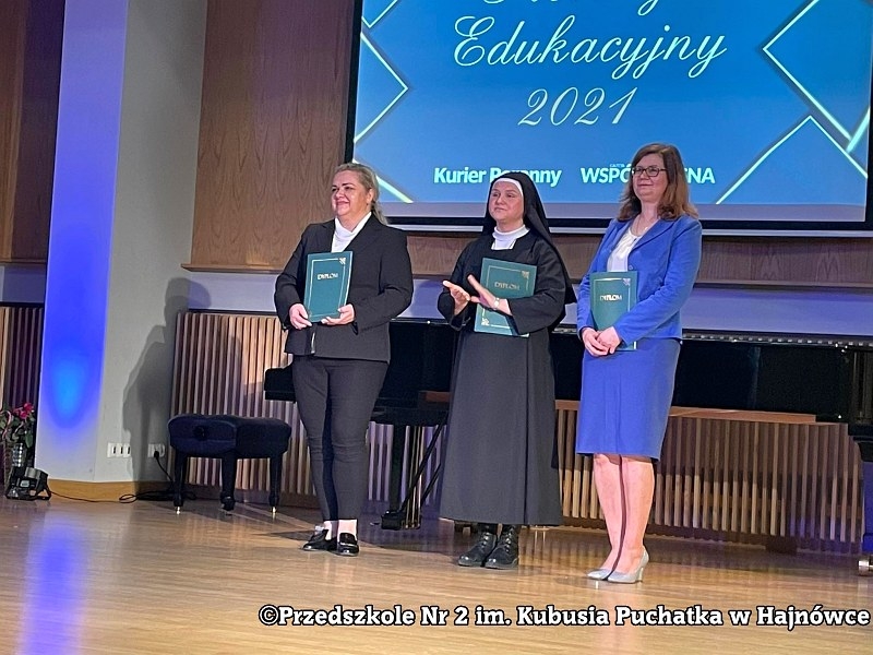 Na zdjęciu trzy kobiety ustawione w rzędzie podczas odbierania wyróżnień.