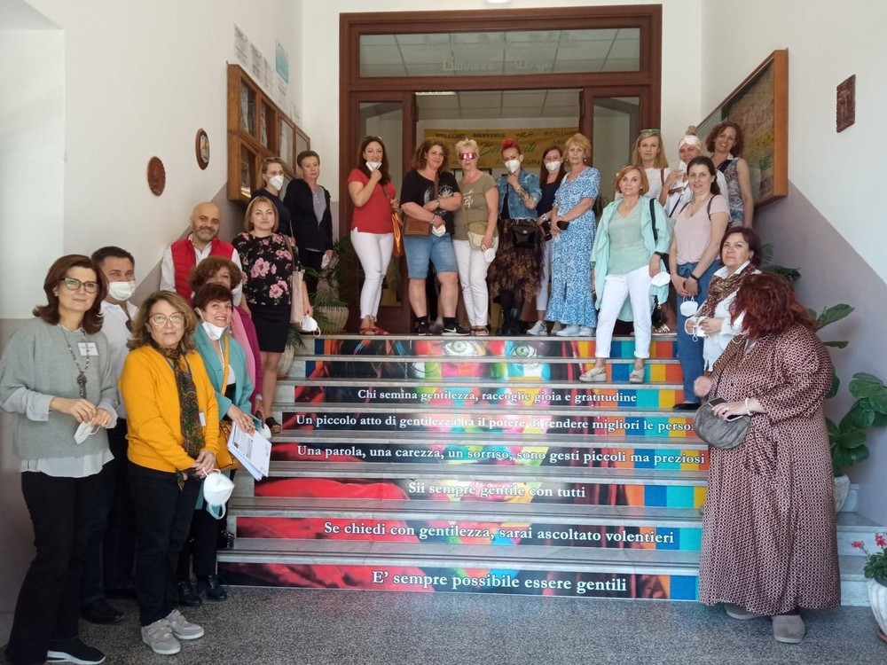 Grupa osób pozuje do zdjęcia na schodach