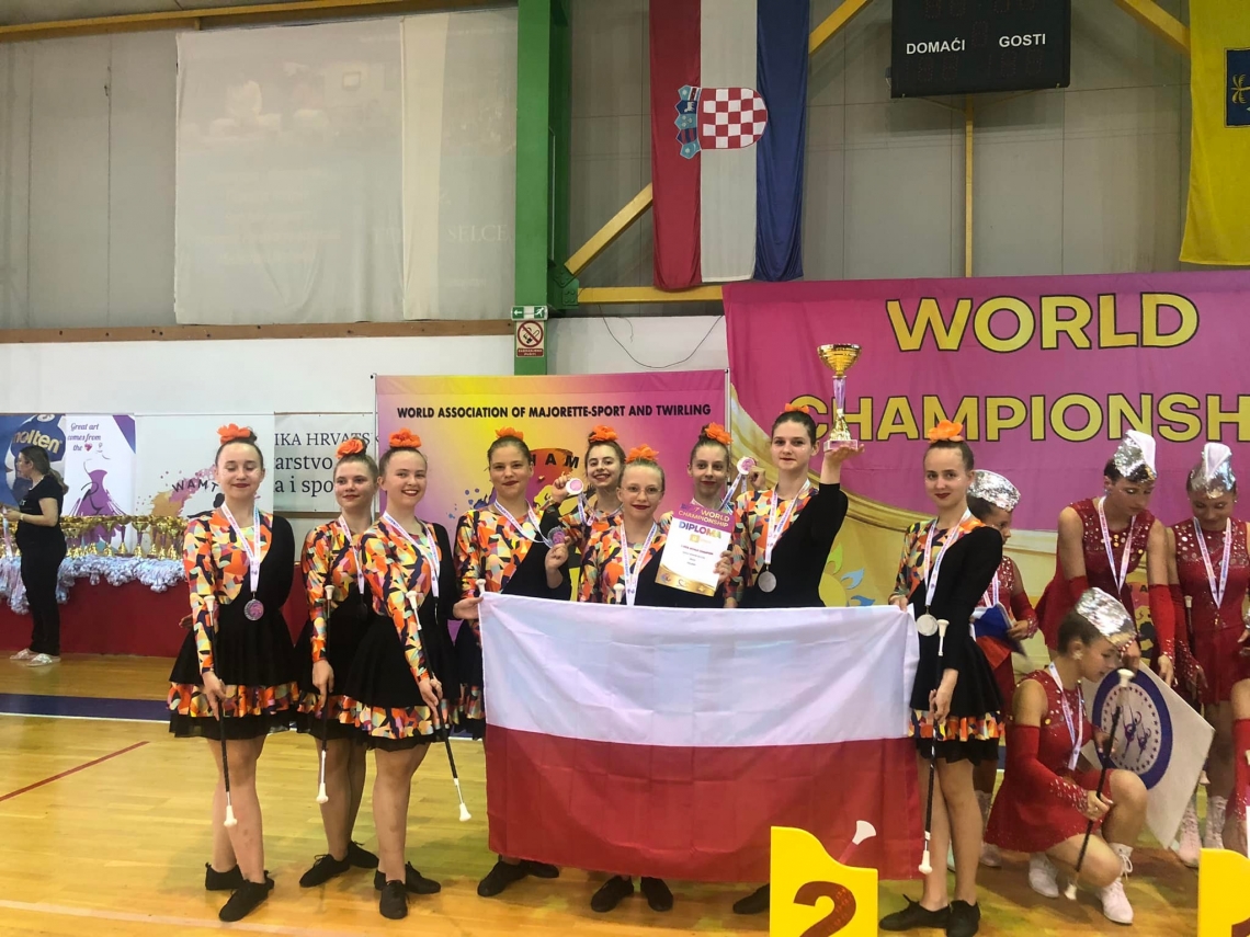 zdjęcie grupowe mażoretek, w rękach trzymają polską flagę