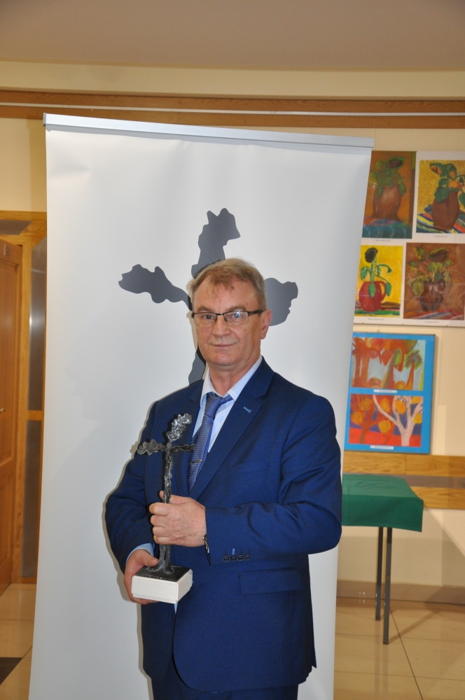 Jerzy Pawluk trzymający statuetkę.