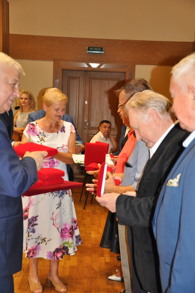 Burmistrz wręcza medal starszemu mężczyźnie.