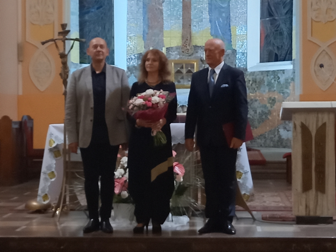 trzej artyści stojący na tle ołtarza