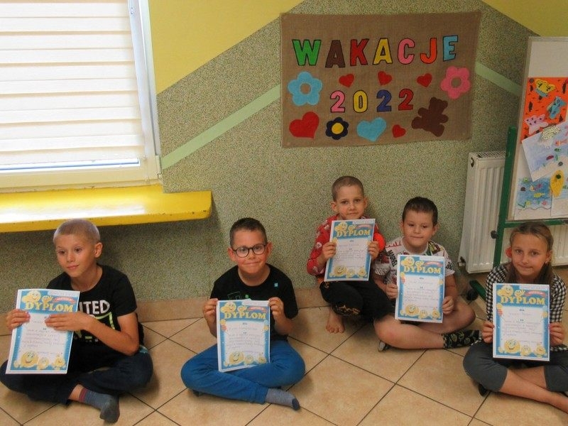 Gupa dzieci trzymająca pamiątkowe dyplomy