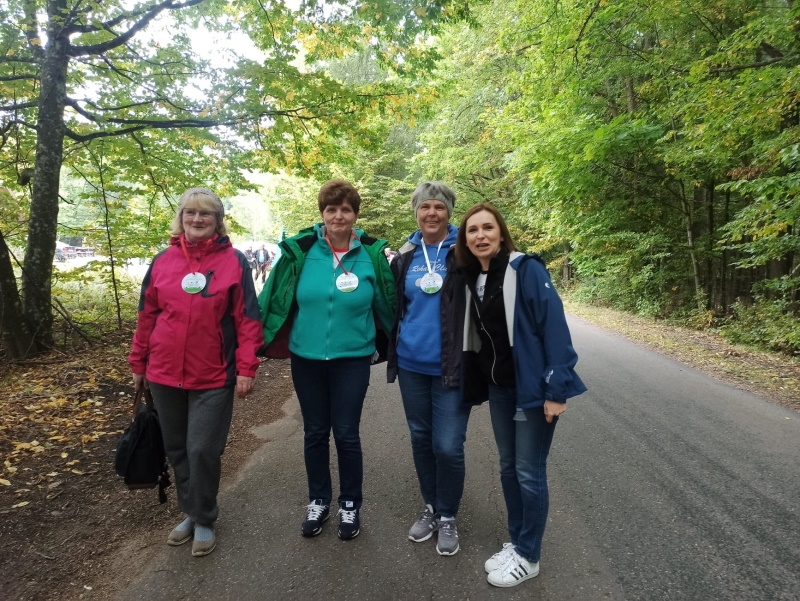 Zdjęcie czterech kobiet w sportowych strojach na tle lasu.