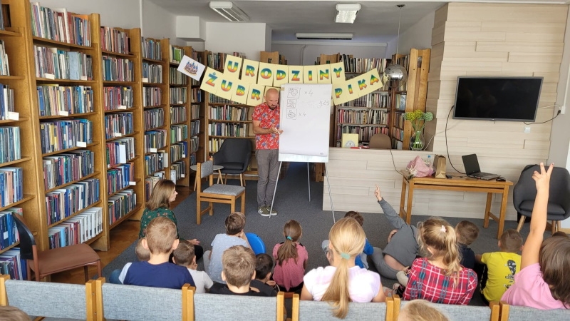 Tomasz Samojlik stoi przed dziećmi.