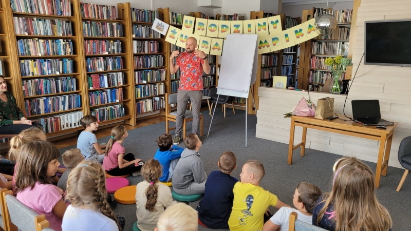 Tomasz Samojlik stoi przed dziećmi.