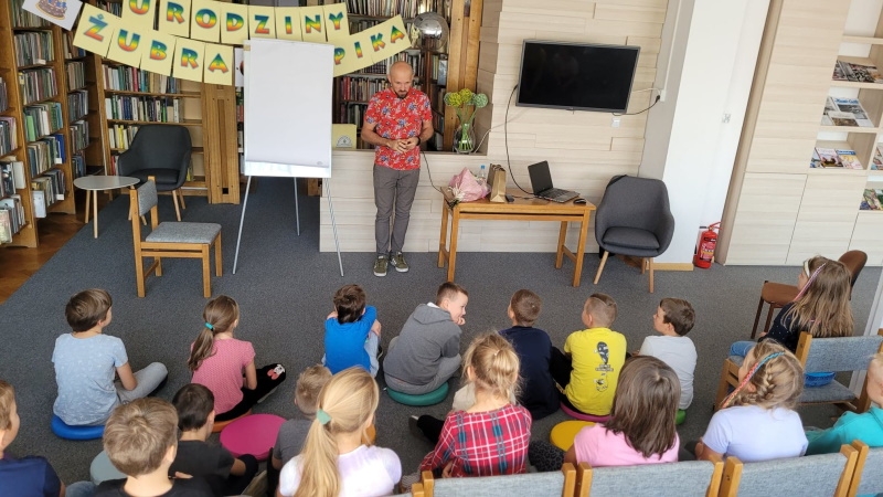 Tomasz Samojlik stoi przed dziećmi.