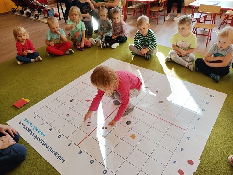 dzieci dobierają w pary rozłożone na macie kartoniki z obrazkami