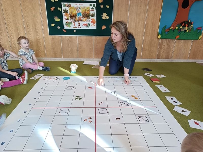 dzieci dobierają w pary rozłożone na macie kartoniki z obrazkami