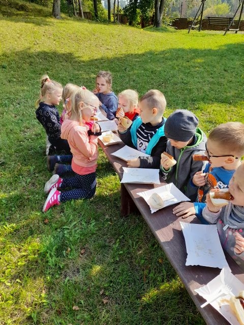 Dzieci jedzą pieczonę kiełbaskę