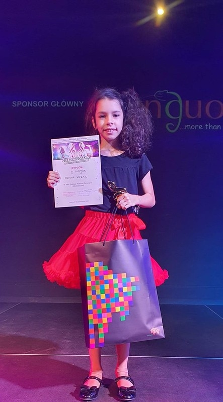 dziewczynka z torbą z logiem województwa podlaskiego i dyplomem