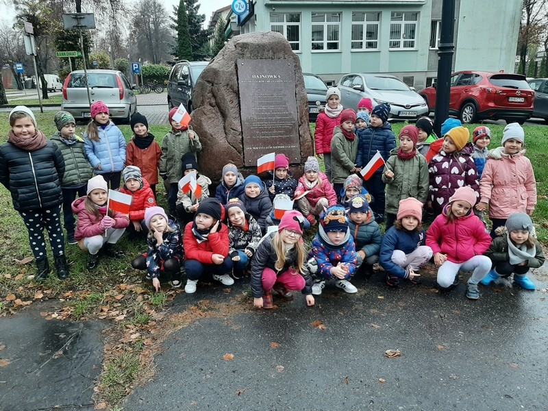grupa dzieci z opiekunkami przy pomniku
